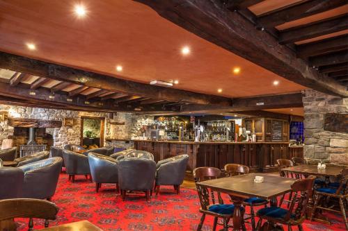 un restaurant avec des tables et des chaises ainsi qu'un bar dans l'établissement The Kings Head Inn, à Llandovery