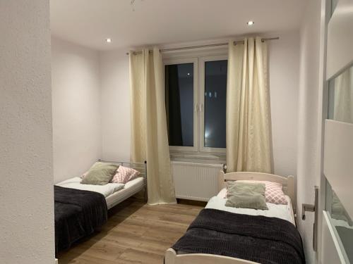 een kleine kamer met 2 bedden en een raam bij Sweet apartament in Tarnowskie Góry