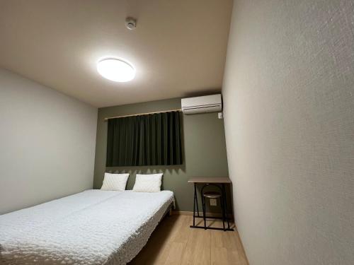 a small room with two beds and a window at Guesthouse Kaede Annex in Nara