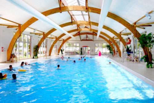 un groupe de personnes dans une piscine dans l'établissement Sea blue dream -2 accès piscines inclus dès 2 nuits-Grand Mobil-home 10 places - MH 735-Siblu ocean, à Gastes