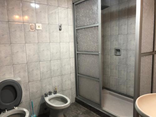 ein Bad mit einer Dusche, einem WC und einem Waschbecken in der Unterkunft Ballivian in Tarija