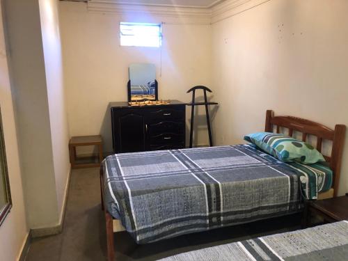 ein Schlafzimmer mit 2 Betten und einer Kommode darin in der Unterkunft Ballivian in Tarija