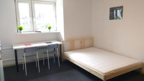 Habitación pequeña con cama y escritorio. en Stilo Dom - ul Nowowiejska en Wroclaw