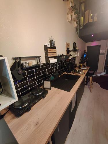 a kitchen with a wooden counter top with a sink at La tentation in Berck-sur-Mer
