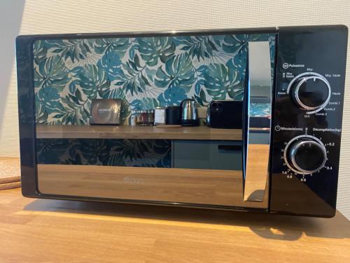 Un four micro-ondes est installé au-dessus d'une table. dans l'établissement Magnifique appartement au coeur de Mulhouse, à Mulhouse