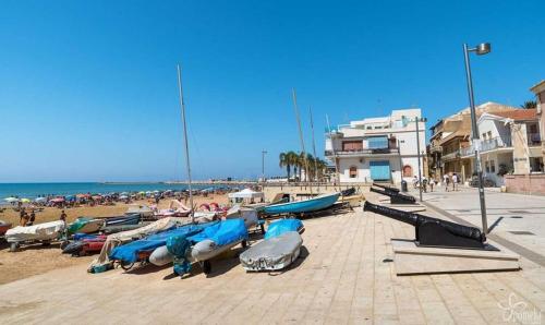 a bunch of boats are lined up on a beach at Debel house in Marina di Ragusa