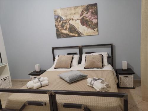 een slaapkamer met een bed met kussens en een schilderij bij mamarita in Sambuca di Sicilia