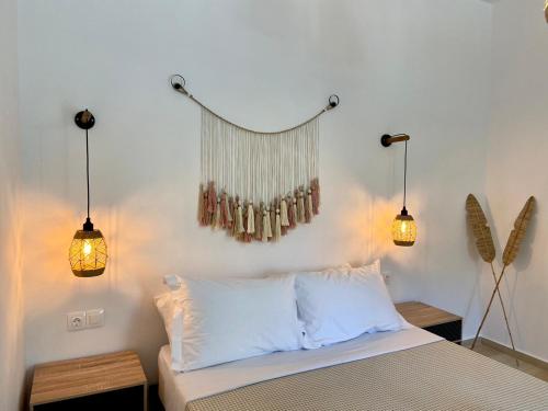 - une chambre avec un lit et deux lumières sur le mur dans l'établissement Batsi Seaside Apartment, à Batsi