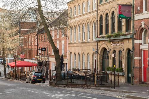 a city street with buildings and a car parked on the street at The Jewellery Suites Birmingham in Birmingham