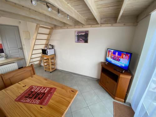 sala de estar con TV y mesa en La Mezza - Wifi - stationnement - Terrasse, en Troyes