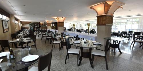 a dining room with tables and chairs in a restaurant at Gran Lençois Flat Residence - Barrerinhas (Aptº Particular) in Barreirinhas