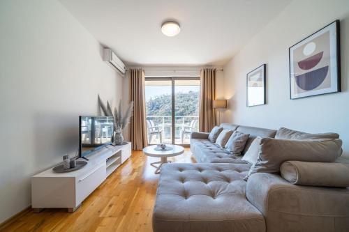 a living room with a couch and a tv at Luxury apartment near beach in Pržno