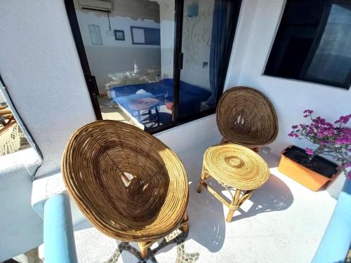two rattan chairs sitting on a porch at Villas Mykonos in Zipolite
