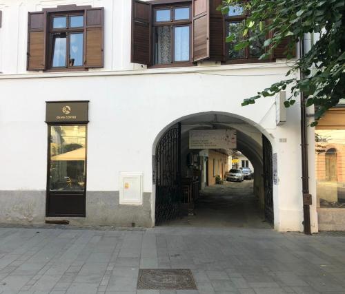 an entrance to a white building with an archway at Gizell Apartment 1 in Sibiu