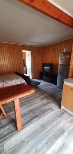 Pokój z łóżkiem i drewnianą podłogą w obiekcie El Capitán w mieście Puerto Montt