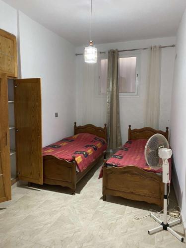 una camera con 2 letti e un ventilatore di Bizerte maison en plein cœur de la médina a Bizerte