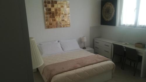 a small bedroom with a bed and a desk at BLANC 59 in Francavilla Fontana