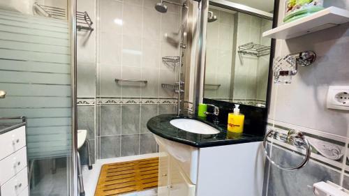 a bathroom with a sink and a shower at Piso Céntrico Nati Con Parking Incluído in O Grove