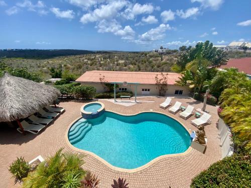 an overhead view of a swimming pool with chairs and a resort at Home Sweet Home Jan Thiel Curacao best view in Jan Thiel