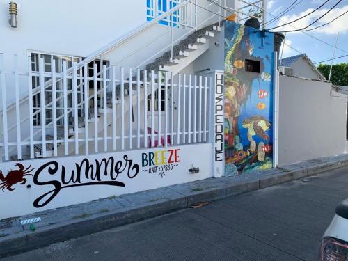 un edificio blanco con un mural en el costado en Summer Breeze en San Andrés