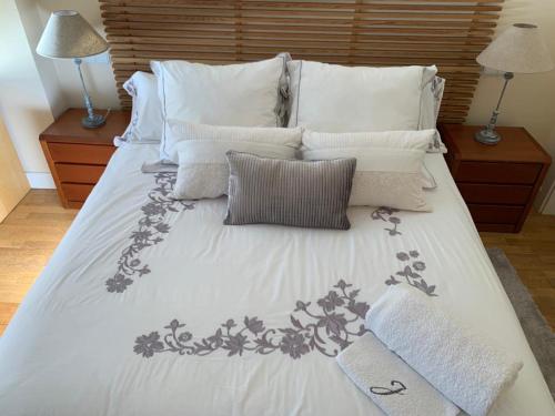 a large bed with white sheets and pillows at Luxury Aparment in Madrid in Madrid