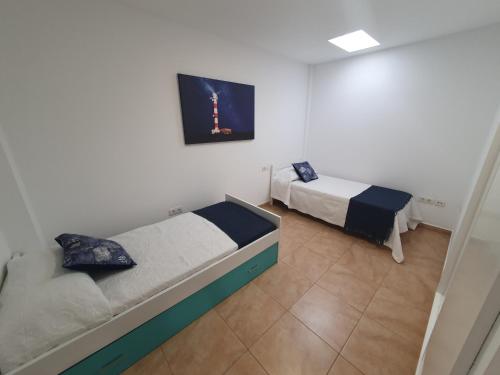 Pokój z dwoma łóżkami i obrazem na ścianie w obiekcie Casa Naihu w mieście La Listada