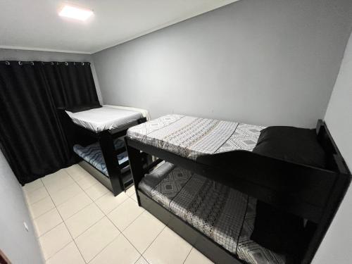 Cette petite chambre comprend 2 lits superposés et un bureau. dans l'établissement Apto Luxo Praia Grande 50m da Praia WI-FI Familiar, à Praia Grande