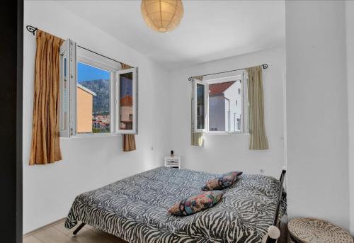 a bedroom with a bed and two windows at Apartman Ita Pet Friendly in Makarska
