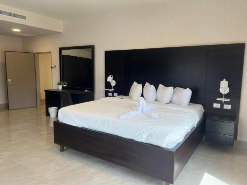 a bedroom with a large bed with white sheets at Mizirawi Historic Hotel in Ramallah