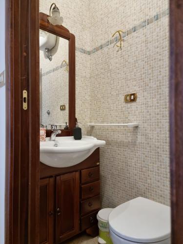 a bathroom with a sink and a toilet and a mirror at Casa Bianca B&B in Ostuni