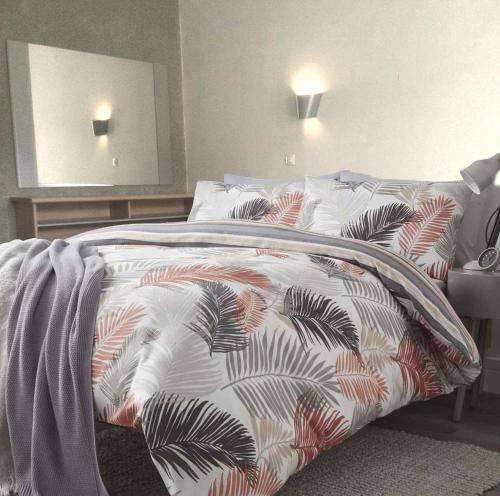 een bed met een dekbed in een slaapkamer bij Sun Dreams Ericeira Apartment in Ericeira