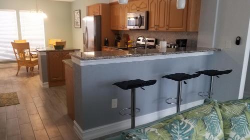 a kitchen and living room with a counter and stools at 2BR/1BA Sienna Park, Sarasota Fl in Sarasota