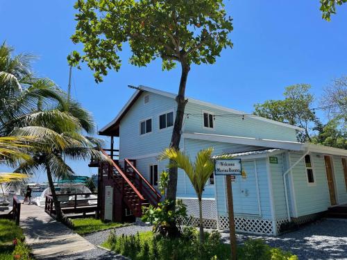 a white house with a tree in front of it at Hotel and Dive Center Roatan Yacht Club in Roatán