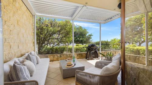 a living room with a couch and a table at Mariners One 1 at 39 Victoria Parade in Nelson Bay