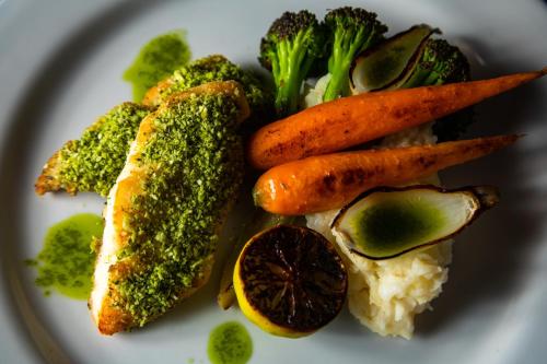 a plate of food with broccoli and carrots and rice at Mariposa Belize Beach Resort in Placencia Village