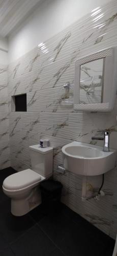 a bathroom with a toilet and a sink and a mirror at Hotel Magic Capurganá in Capurganá