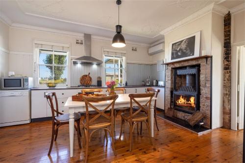 a kitchen with a table and chairs and a fireplace at Hanigans Cottage in Bolong