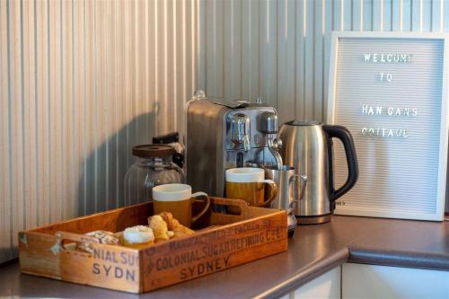 a wooden tray with cups and coffee cups on a counter at Hanigans Cottage in Bolong