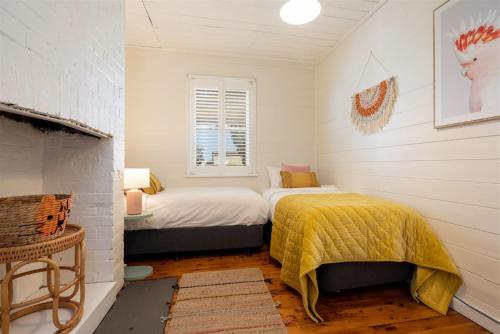 Un dormitorio con dos camas y una ventana. en Hanigans Cottage, en Bolong