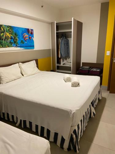 een slaapkamer met een groot wit bed in een kamer bij Olímpia Park Resort Apto in Olímpia