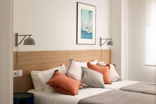 a bedroom with a bed with orange and white pillows at Santa Ana junto a la ria a estrenar garaje y wifi incluidos in Bilbao