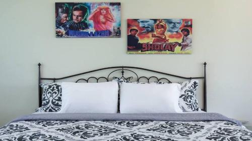 two posters on the wall above a bed at La Esmeralda PR in San Juan