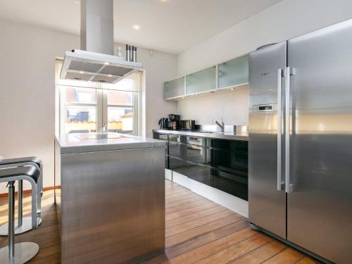 a kitchen with stainless steel appliances and wooden floors at 6 person holiday home in Skagen-By Traum in Skagen