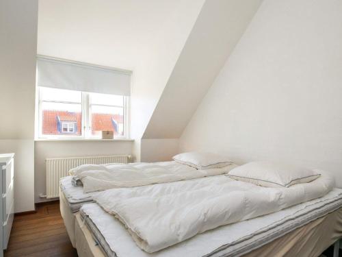 two beds in a white room with a window at 6 person holiday home in Skagen-By Traum in Skagen