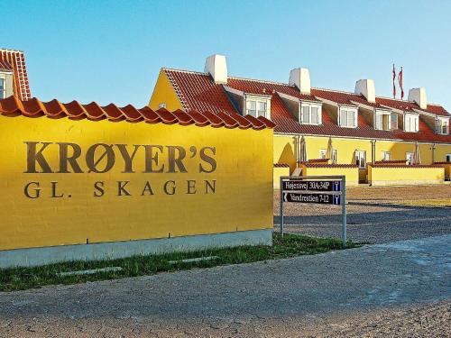 a yellow building with a sign that reads kroyers g stayer at 6 person holiday home in Skagen-By Traum in Skagen