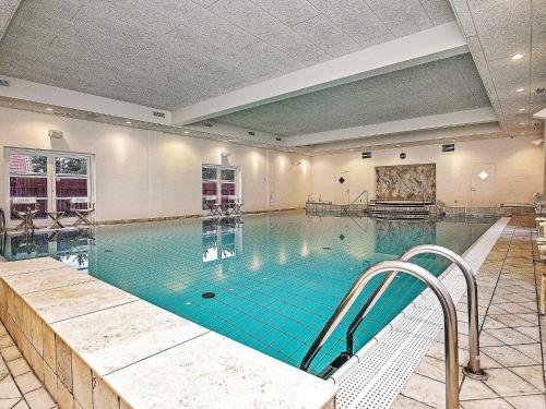 a large indoor swimming pool with blue water at 6 person holiday home in Skagen-By Traum in Skagen