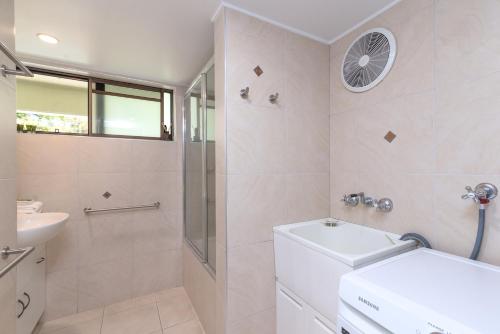 a bathroom with a shower and a toilet and a sink at Seascape Holidays - Tropical Reef Apartments in Port Douglas