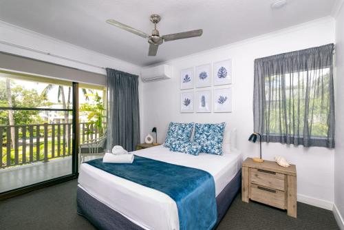 a bedroom with a bed and a window at Seascape Holidays - Tropical Reef Apartments in Port Douglas