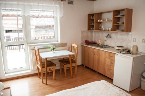 eine Küche mit einem Tisch, Stühlen und einem Waschbecken in der Unterkunft Ubytovanie v Súkromi Habovka in Habovka