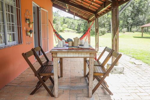 una mesa de madera con 2 sillas en el patio en REFÚGIO FAMILIA, descanso e conexão c natureza, en Ibiúna